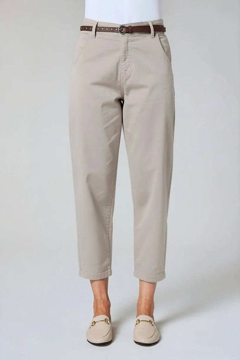 A person wearing light beige cropped pants with a brown belt, paired with beige loafers, shown against a plain light gray studio background by Weirs Gifts