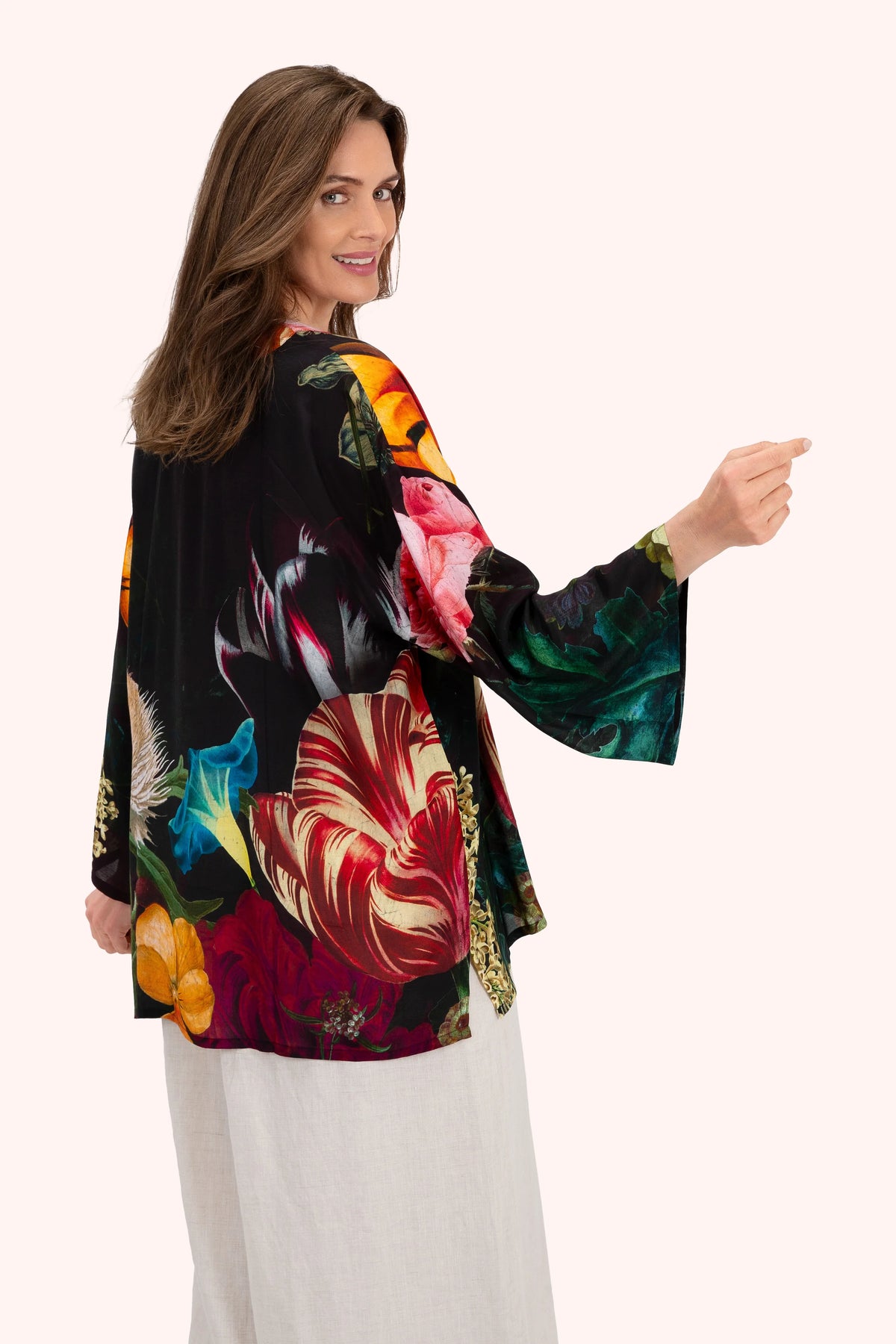 Woman wearing a colorful floral kimono-style jacket on a white background by Weirs Gifts