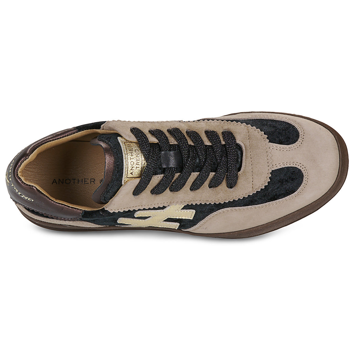 A top-down view of a low-top sneaker by Another London, featuring beige suede and black nubuck panels, black laces, and a gold-tone logo on the side at Weirs Gifts