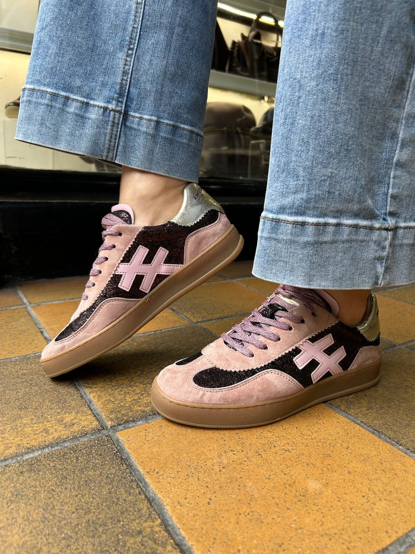 A low-top sneaker in light pink suede and glittery dark pink with a metallic silver heel counter, featuring a light pink cross logo on the side and a gum sole at Weirs Gifts