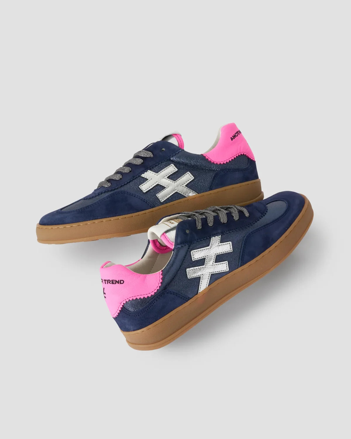 Navy sneakers with pink accents and white logo on a light gray background by Weirs Gifts