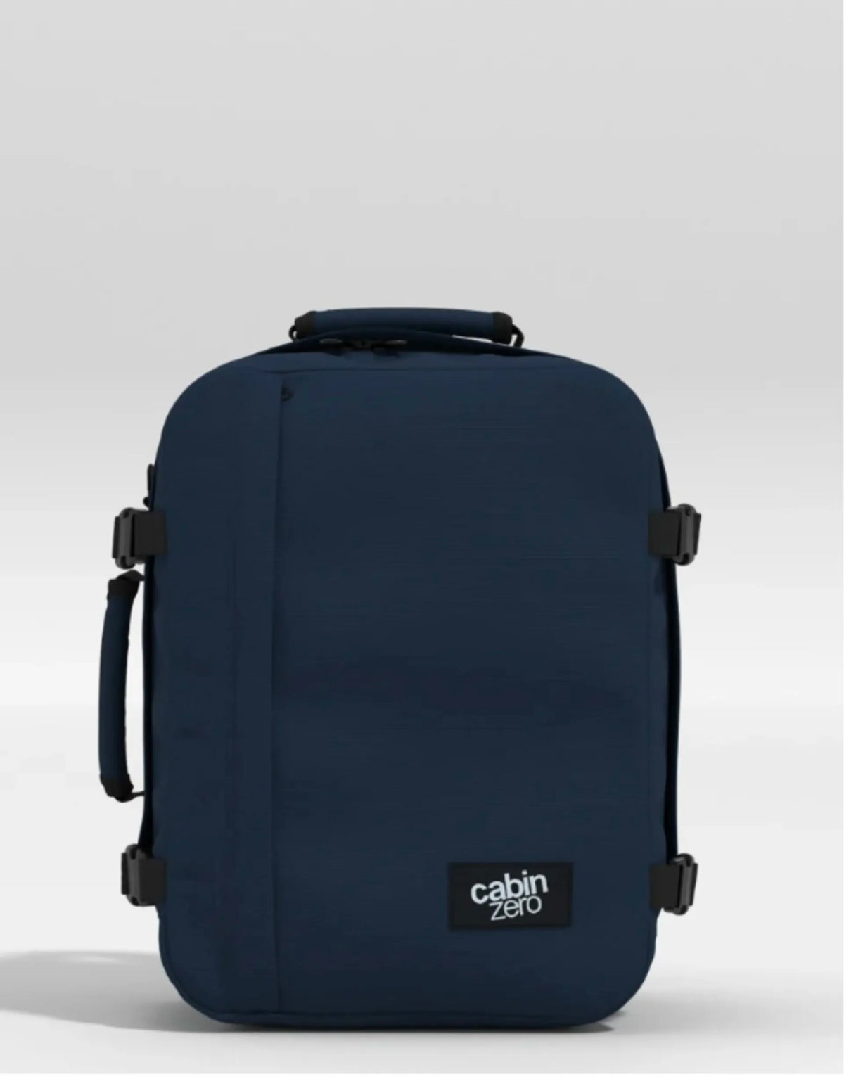 A dark navy blue Cabin Zero backpack with black straps and a black brand label on the front, set against a light gray studio background.