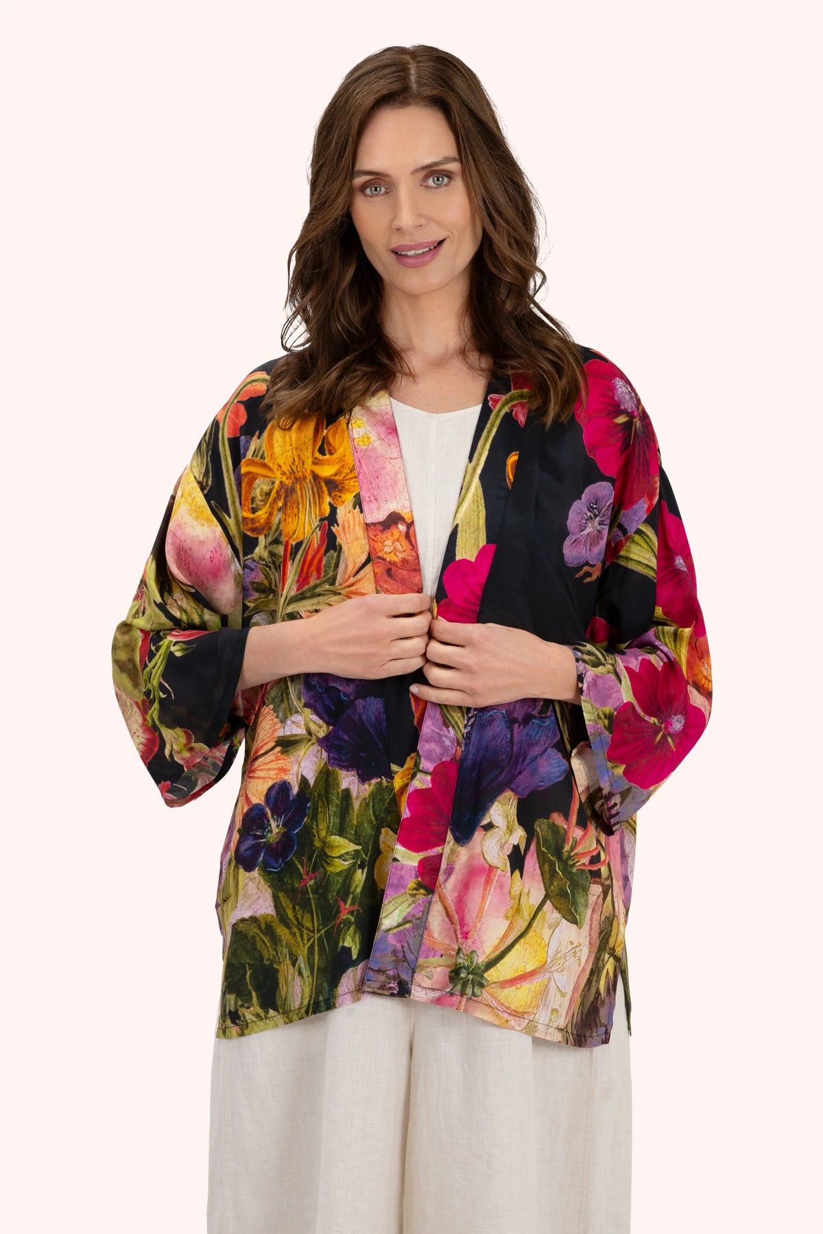 Woman wearing a colorful floral kimono-style jacket on a white background by Weirs Gifts