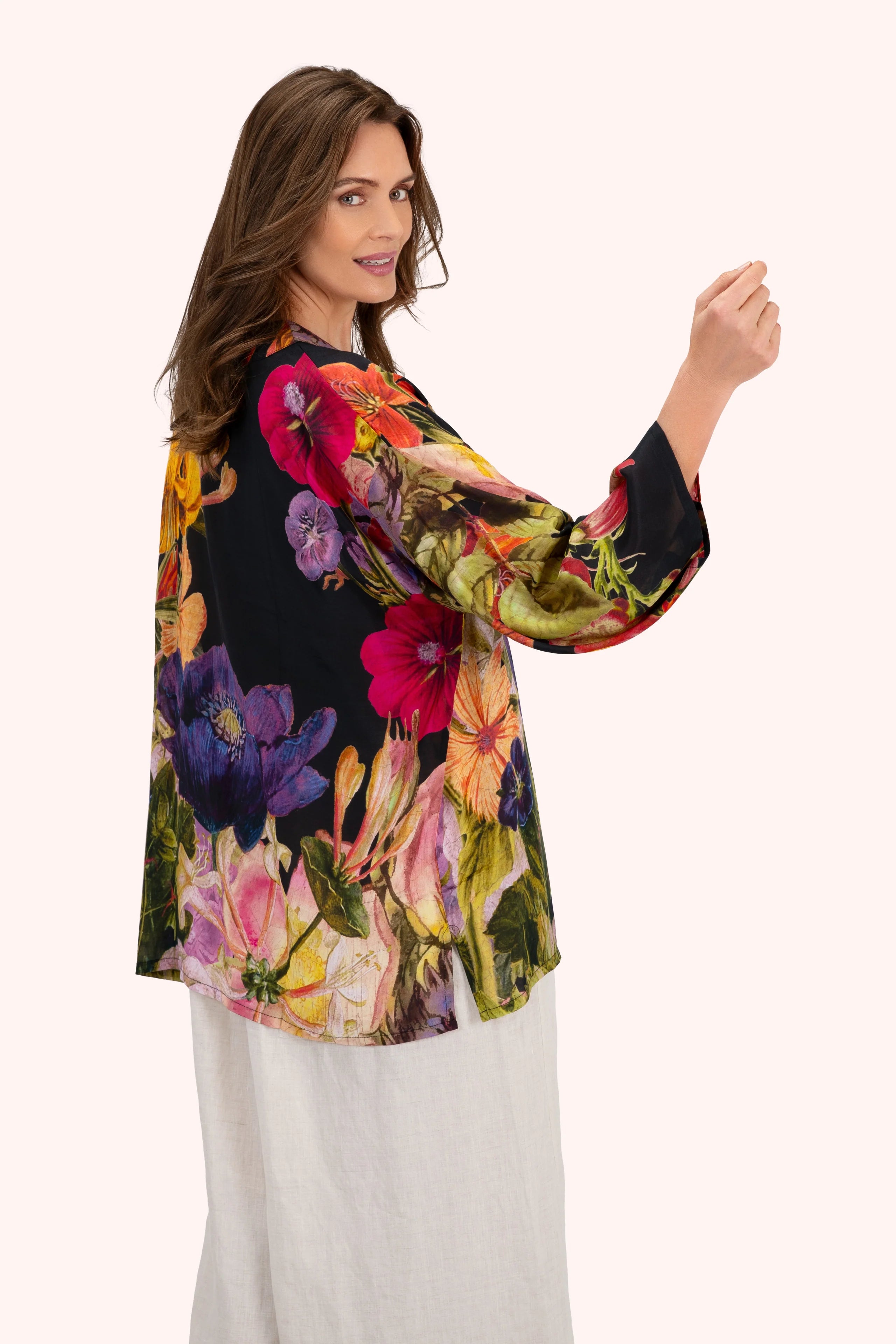 Woman wearing a colorful floral blouse with a white background by Weirs Gifts