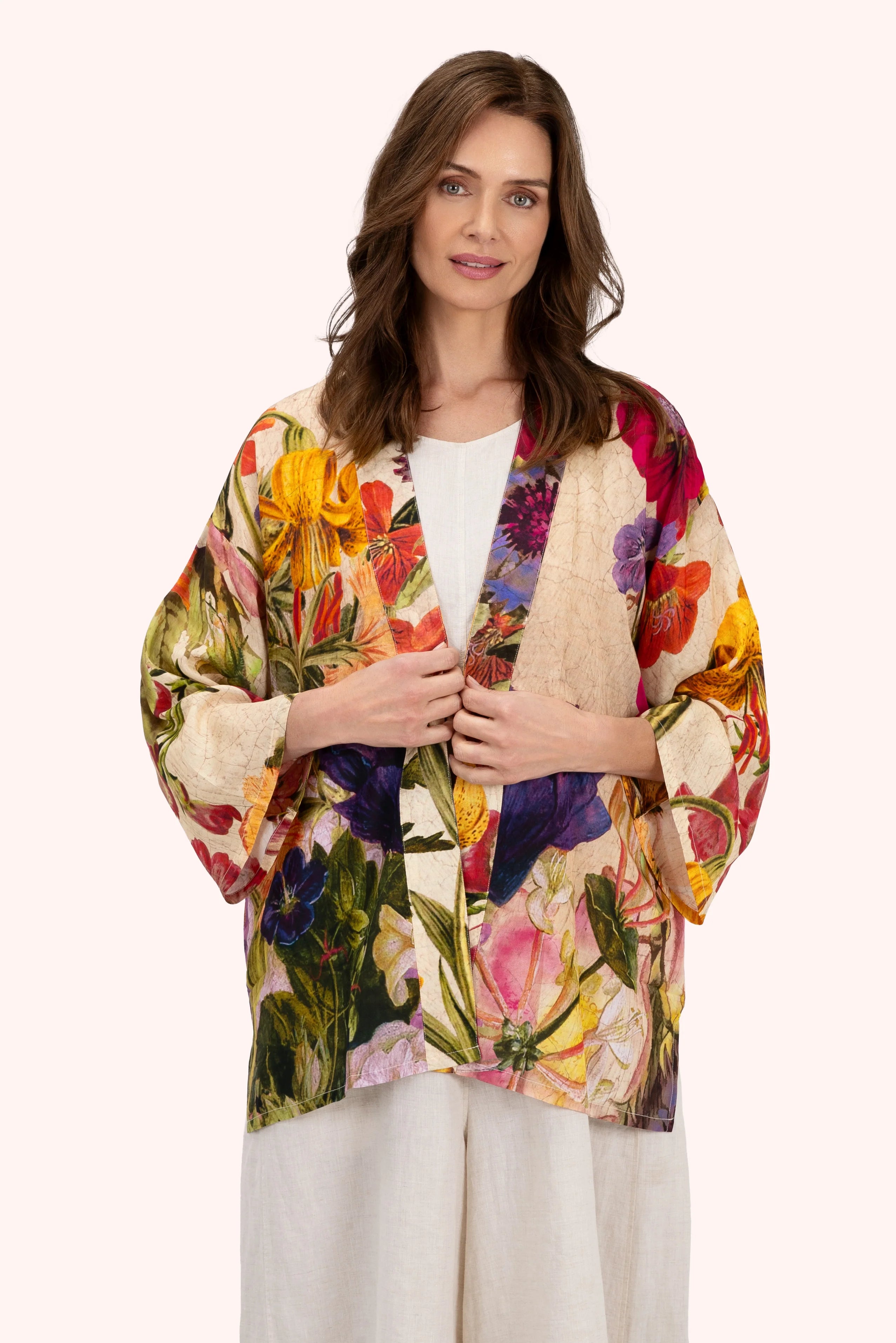 Woman wearing a colorful floral kimono-style jacket on a white background by Weirs Gifts