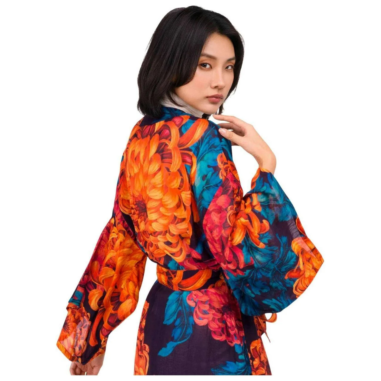 A model wearing a vibrant floral kimono-style robe with orange chrysanthemums, blue leaves, and a dark purple base, shown from a three-quarter back view against a solid white background by Weirs Gifts