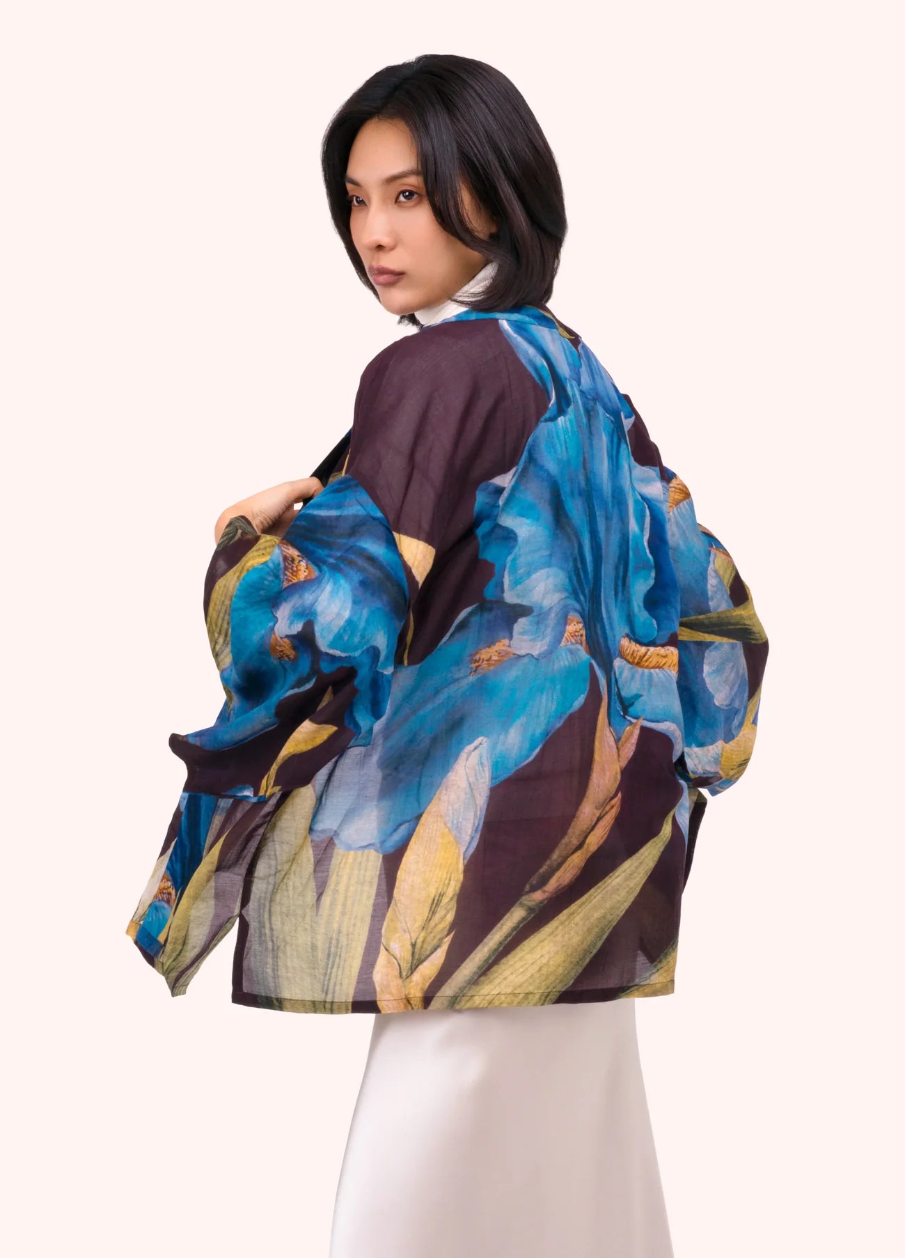 Woman wearing a colorful floral jacket on a white background by Weirs Gifts